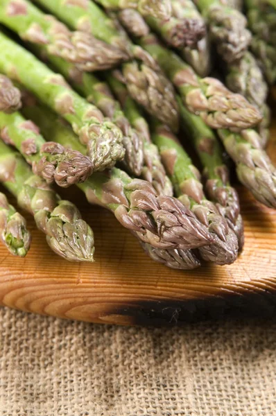 Mazzo di asparagi freschi su fondo legno — Foto Stock