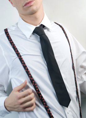 Young businessman in white shirt, black tie and suspenders on white background clipart