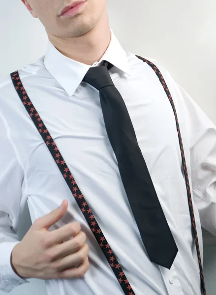 Jeune homme d'affaires en chemise blanche, cravate noire et bretelles sur fond blanc — Photo