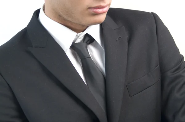 Jeune homme d'affaires beau en costume noir sur blanc . — Photo
