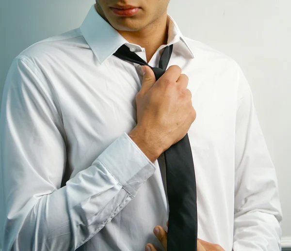 Retrato de un joven guapo y elegante atar una corbata — Foto de Stock
