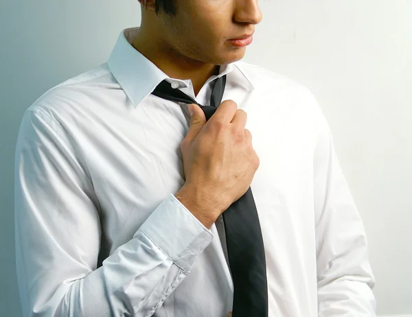 Портрет красивого стильного молодого человека завязать галстук — стоковое фото