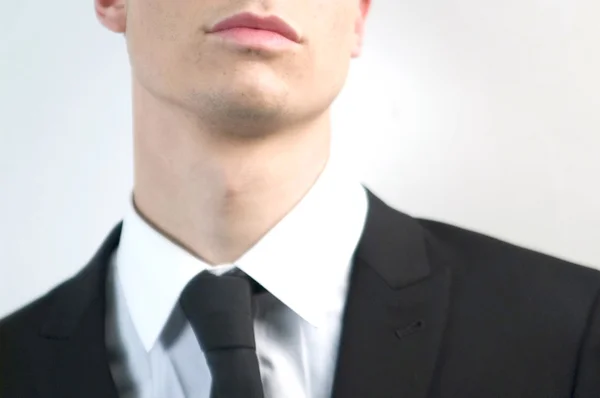 Νεαρό όμορφος επιχειρηματία στο μαύρο κοστούμι σε λευκό. — Φωτογραφία Αρχείου