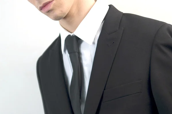 Молодой привлекательный бизнесмен в черном костюме на белом . — стоковое фото