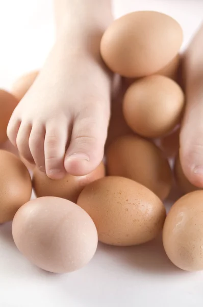 鸡蛋与孩子们的脚 — 图库照片
