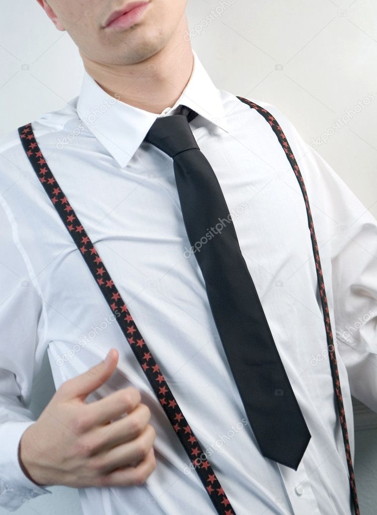 Young businessman in white shirt, black tie and suspenders on white background