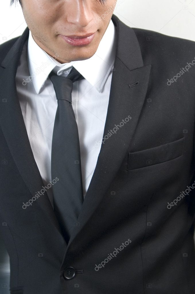 Young handsome businessman in black suit on white.