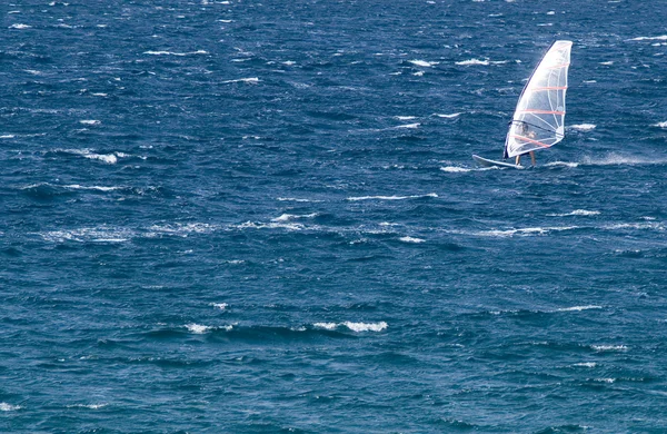 Одинокий виндсерфер в океане ловит волну — стоковое фото
