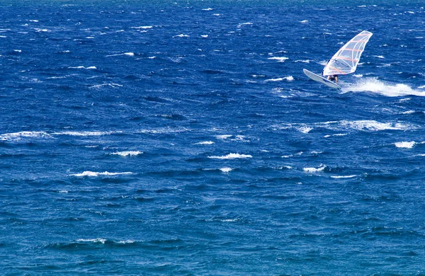 Windsurfista solitario en el océano cogiendo una ola — Foto de Stock