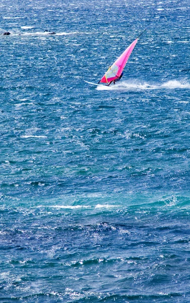 Lone windsurfer in the ocean catching a wave — Stock Photo, Image