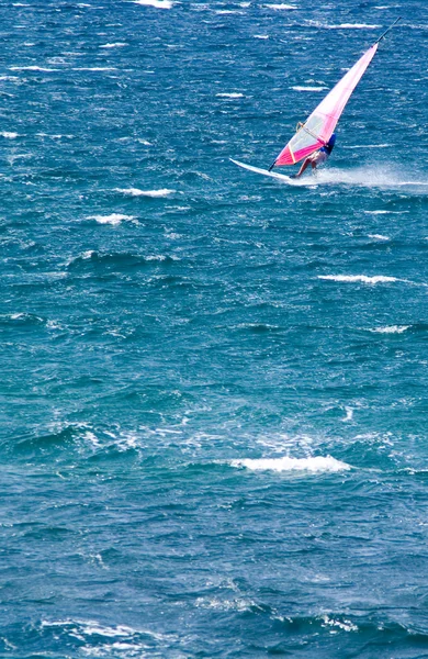 Einsamer Windsurfer im Meer, der eine Welle fängt — Stockfoto