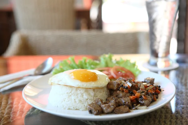 Roast beef with black pepper and fried egg on rice — Stock Photo, Image