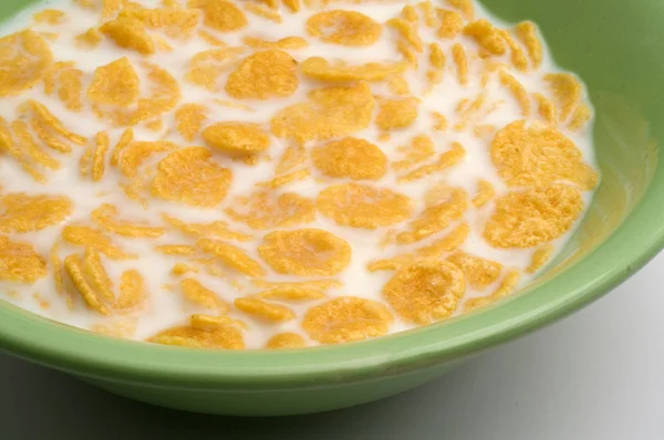 Stock image Cornflakes and milk in green plate close up