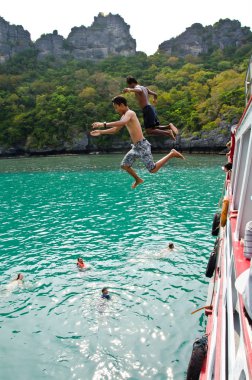 Travellers leap from the deck into the water. clipart