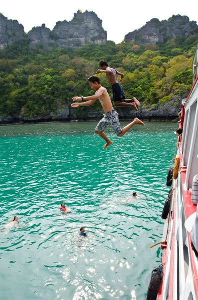 Travellers leap from the deck into the water. — Stock Photo, Image