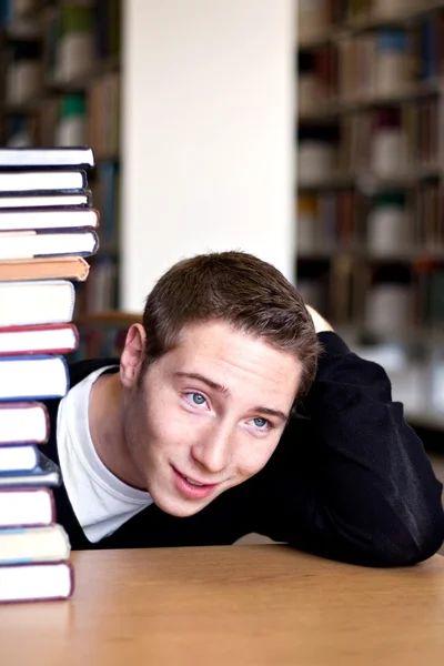 Przytłoczony studenta z książki ułożone — Zdjęcie stockowe