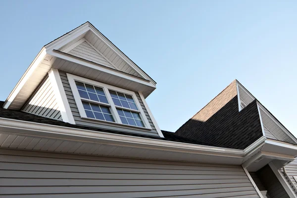 新しい家の頂点とガッターズ屋根窓 — ストック写真