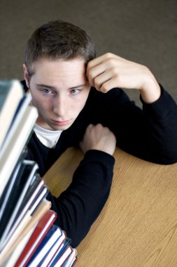 Overloaded Student Looking At Pile of Books clipart