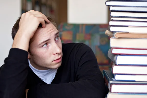 Stressad student ser på böcker — Stockfoto