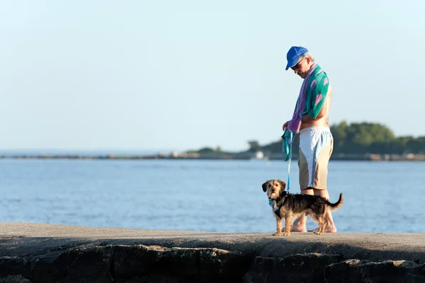 Чоловік середнього віку гуляє собакою — стокове фото