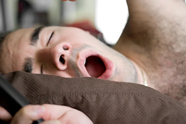 Άνθρωπος χασμουρητό στο κρεβάτι — Φωτογραφία Αρχείου