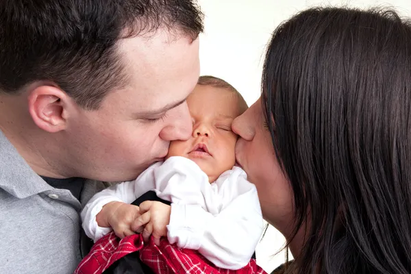 Pais felizes beijam seu bebê recém-nascido — Fotografia de Stock