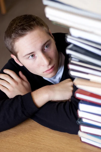 Estudante estressado olha para livros — Fotografia de Stock