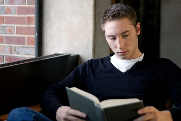 Student lezen in de bibliotheek — Stockfoto