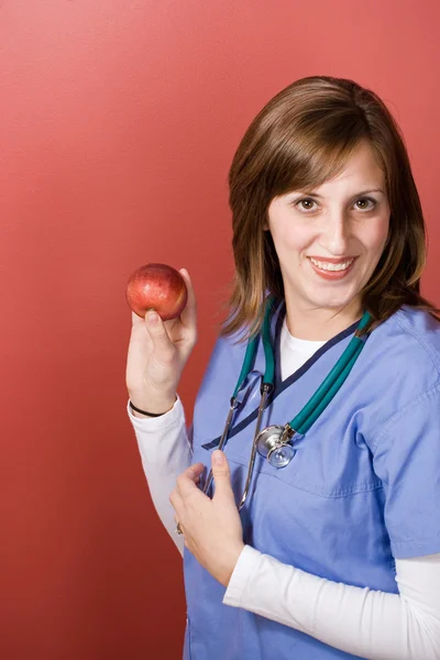 Медсестра с яблоком — стоковое фото