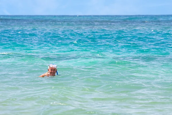 Anziani che fanno snorkeling nelle acque tropicali — Foto Stock