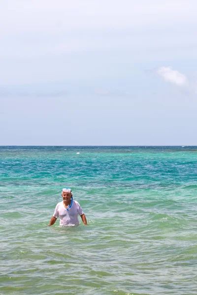 Anziani che fanno snorkeling nelle acque tropicali — Foto Stock