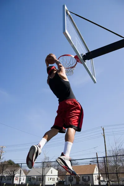 Człowiek dunking koszykówki — Zdjęcie stockowe