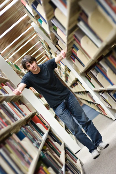 Mladý muž v knihovně — Stock fotografie