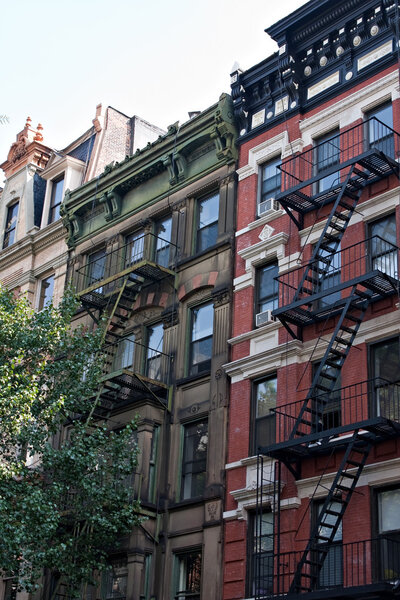 Some vintage tenement buildings with iron fire escapes.