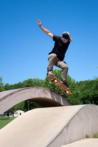 Скейтбордист совершил прыжок в бетонном скейт-парке — стоковое фото