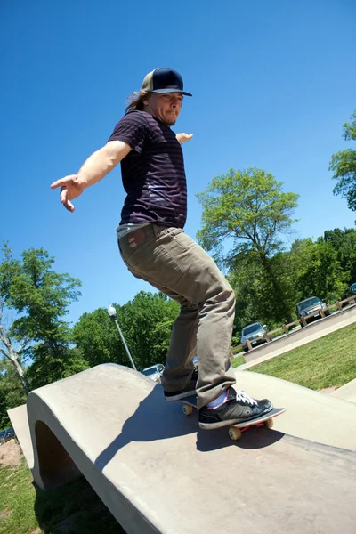Skateboardista železniční broušení na betonové skate park — Stock fotografie