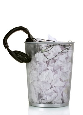 Headphones and paper in metal trash bin isolated on white clipart