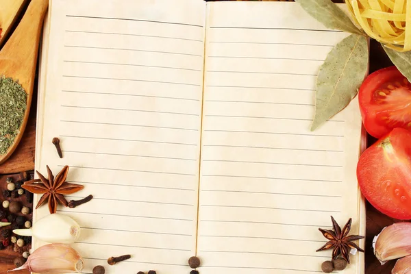 Caderno de receitas e especiarias em mesa de madeira — Fotografia de Stock