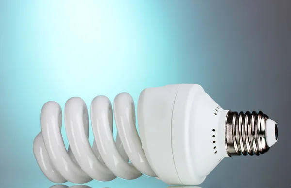 Energy saving light bulb on blue background — Stock Photo, Image
