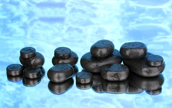 Spa taşlar ile mavi arka plan üzerinde damlacıklar — Stok fotoğraf