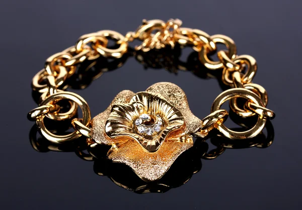 Mooie gouden armband met edelstenen op grijze achtergrond — Stockfoto