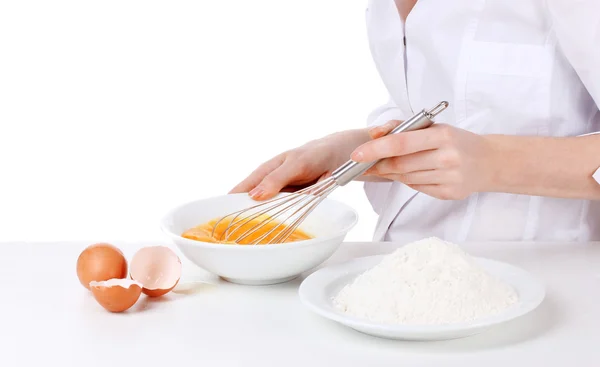 Γυναικεία χέρια Αναμιγνύοντας αυγά σε μπολ απομονώνονται σε λευκό — Φωτογραφία Αρχείου