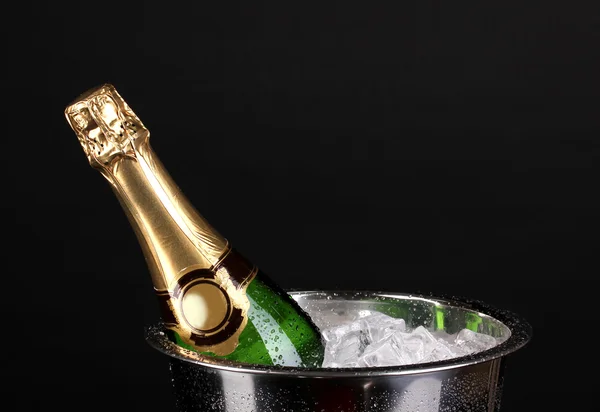 Butelka szampana w wiaderko na czarnym tle — Zdjęcie stockowe