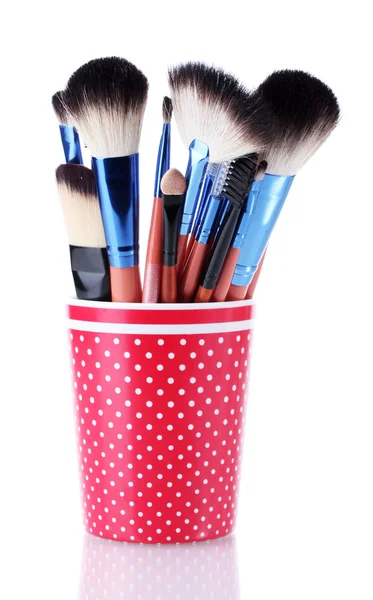 Pinceles de maquillaje en taza roja aislados en blanco — Foto de Stock
