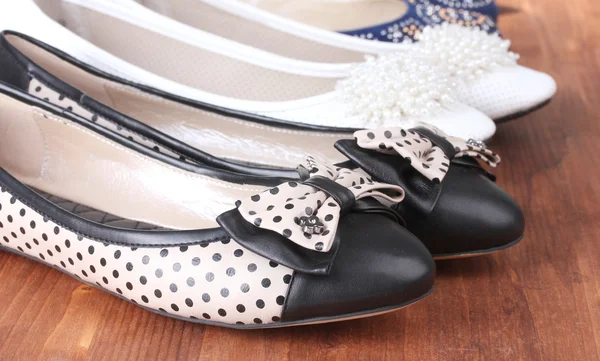 Několik párů ženských plochých bot na dřevěné pozadí — Stock fotografie