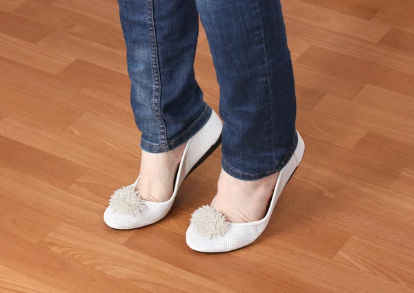 Piernas en jeans y zapatos planos de ballet sobre fondo de madera —  Fotos de Stock