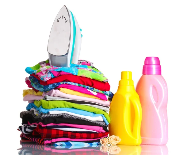 Pile of colorful clothes and electric iron with detergent isolated on white — Stock Photo, Image