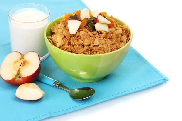 在与干水果、 牛奶和蓝餐巾上的苹果的玻璃碗可口脆玉米片 — 图库照片