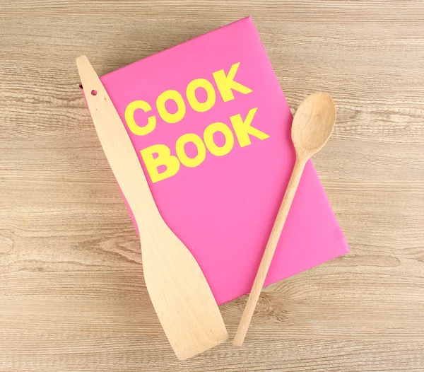 Kochbuch und Geschirr auf Holzgrund — Stockfoto