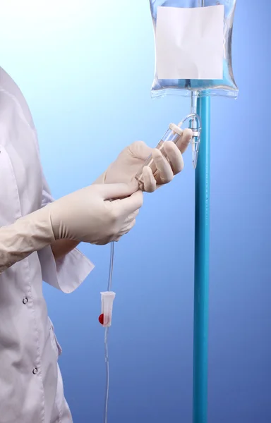Verpleegkundige doen infusie op blauwe achtergrond — Stockfoto